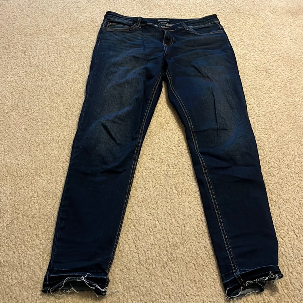 Dark jeans with distressed ankles